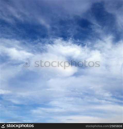 Wispy cloud formations against clear blue sky.