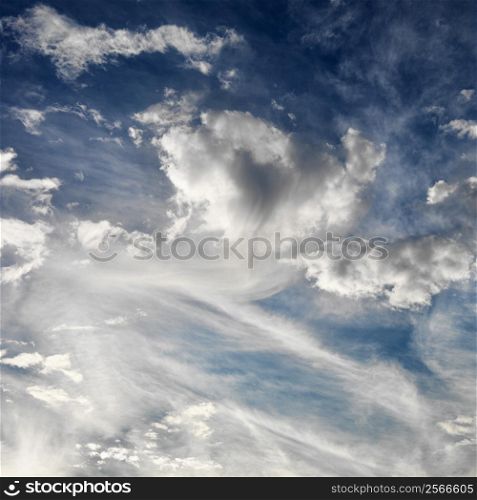 Wispy cloud formations against clear blue sky.
