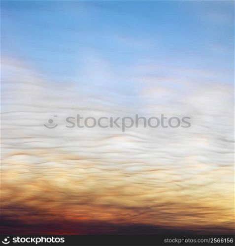 Wispy clouds in sunset colored sky.