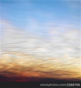 Wispy clouds in sunset colored sky.