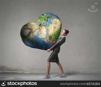 With care and love to our planet. Attractive businesswoman carrying Earth planet in hands. Elements of this image are furnished by NASA