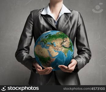 With care and love to our planet. Close view of businesswoman holding Earth planet in hands. Elements of this image are furnished by NASA