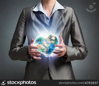 With care and love to our planet. Close view of businesswoman holding Earth planet in hands. Elements of this image are furnished by NASA