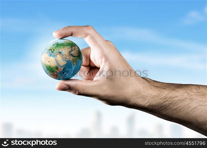 With care to our planet. Small Earth planet between male fingers. Elements of this image are furnished by NASA