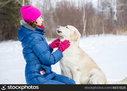 With her best friend. Girl with labrador dog on walk in winter park