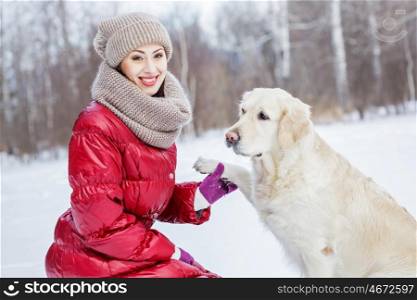 With her best friend. Girl with labrador dog on walk in winter park
