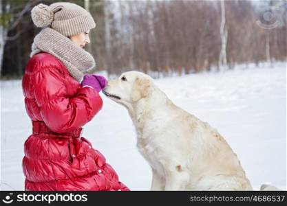 With her best friend. Girl with labrador dog on walk in winter park