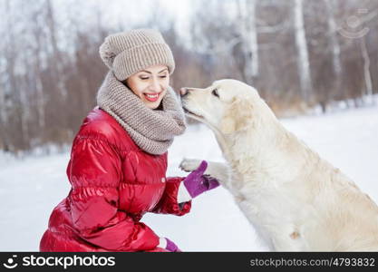 With her best friend. Girl with labrador dog on walk in winter park