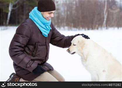 With his best friend. Guy with labrador dog on walk in winter park