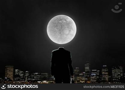 With moon on shoulders. Faceless businessman with moon planet instead of head