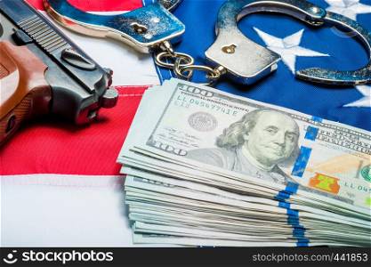 Withdrawn money and weapons on the American flag - a crime and punishment concept photo