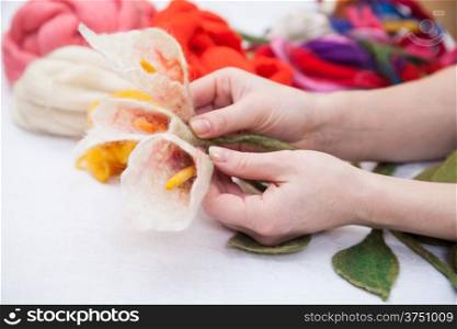 Woman&#39;s hands holding white felted calla lilies
