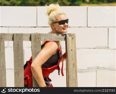 Woman about to do some work on construction site holding wooden Euro pallets. Woman working with pallets on construction site