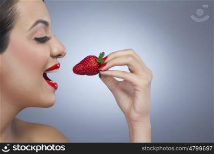 Woman about to eat a strawberry
