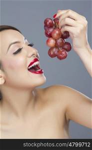 Woman about to eat grapes