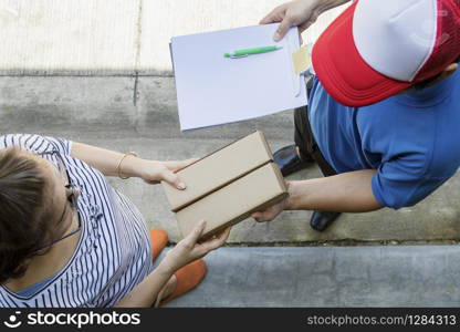 woman accepting on line shopping product from home delivery man ,top view scene