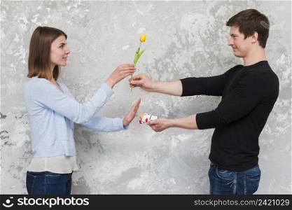 woman accepting yellow tulip flower no cigarette packet offering by handsome man