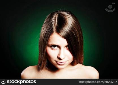 Woman&acute;s beautiful face closeup portrait on green background