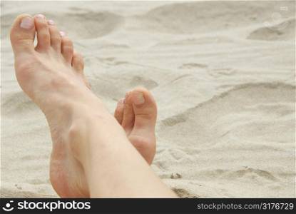 Woman&acute;s feet on a sandy beach