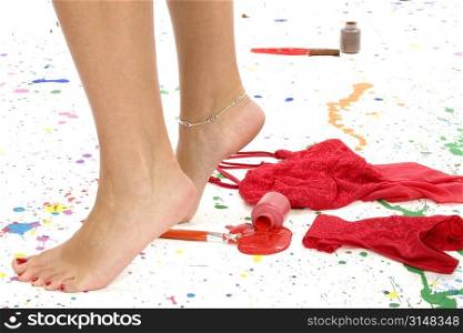 Woman&acute;s feet tip-toeing away from sexy lingerie and paint.