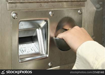 Woman&acute;s hand taking coins from a bill change machine.