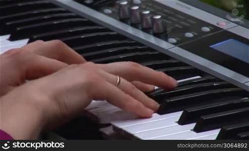 woman&acute;s hands playing a keyboard