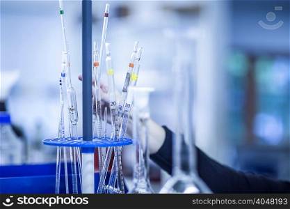 Woman adjusting lab tubes in laboratory, focus on tubes