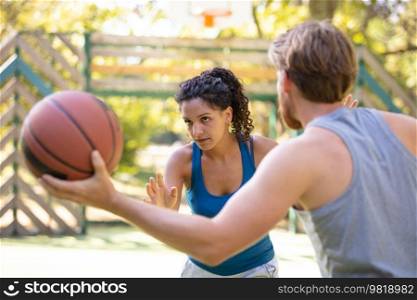woman against a man playing basketball