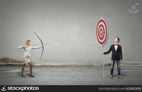 Woman aiming her goal. Young businesswoman aiming with archer to make shot