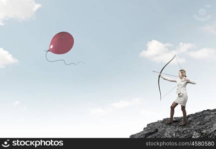 Woman aiming her goal. Young businesswoman aiming with archer to make shot