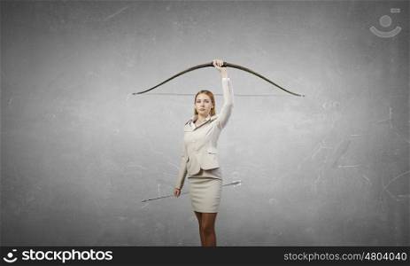Woman aiming her goal. Young businesswoman aiming with archer to make shot