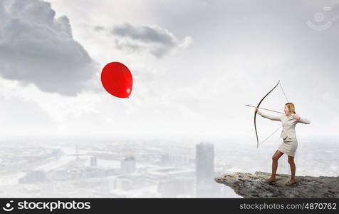 Woman aiming her goal. Young businesswoman aiming with archer to make shot