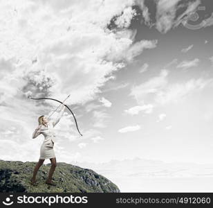 Woman aiming her goal. Young businesswoman aiming with archer to make shot