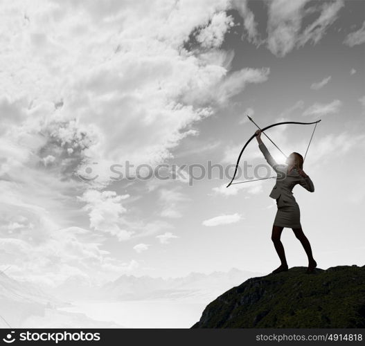 Woman aiming her goal. Young businesswoman aiming with archer to make shot