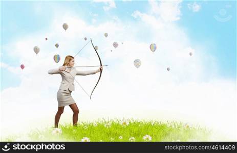 Woman aiming her goal. Young woman archer in suit aiming to make shoot