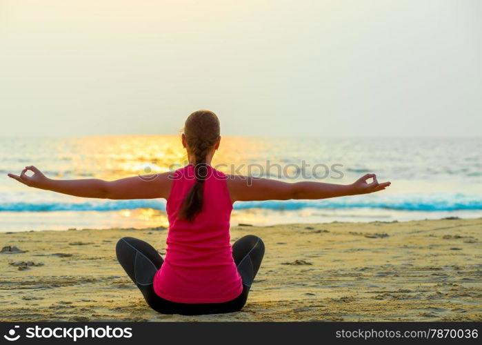 woman alone does yoga at sunset on the sea