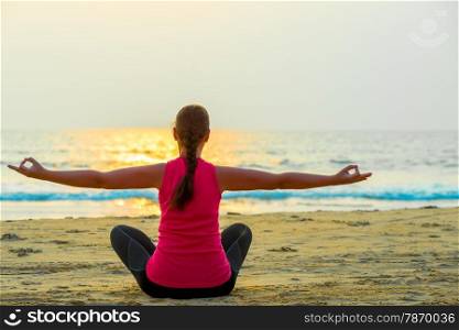 woman alone does yoga at sunset on the sea