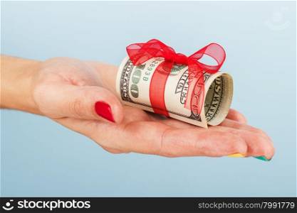 woman&amp;#39;s hand is holding money on the blue background.. Dollar bills