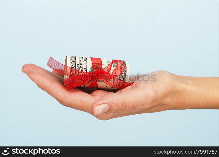woman&amp;#39;s hand is holding money on the blue background.. Dollar bills
