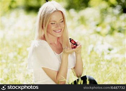 Woman and butterfly. Beautiful blond woman playing with butterfly in spring park