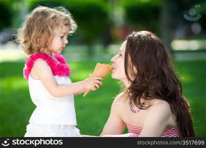 Woman and child eating ice-cream in spring park