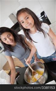 Woman and child preparing dough in kitchen