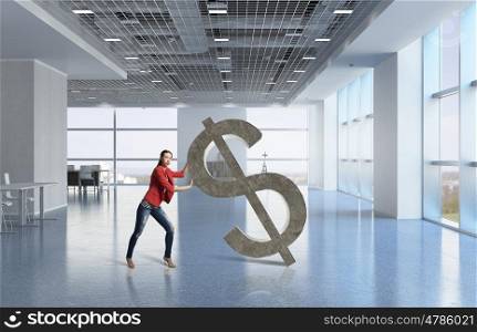 Woman and dollar currency sign. Young woman in modern interior pushing dollar symbol
