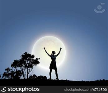 Woman and full moon. Silhouette of woman on hill at night