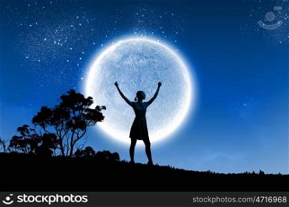Woman and full moon. Silhouette of woman on hill at night