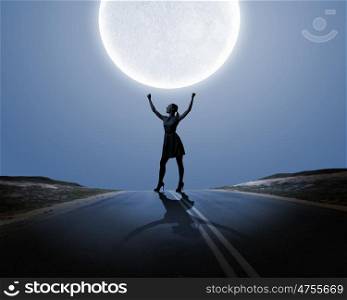 Woman and full moon. Silhouette of woman on road at night