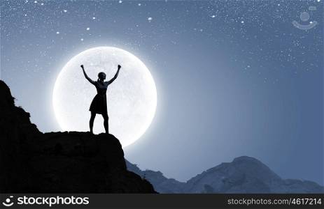 Woman and full moon. Silhouette of woman on top of hill at night