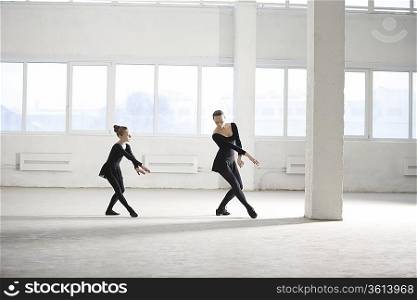 Woman and girl practise dance moves