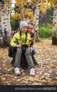 Woman and her son with camera. Woman and her son with camera in autumn forest