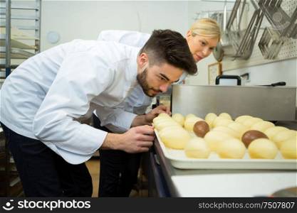 woman and man busy preparing a chocolate eggs